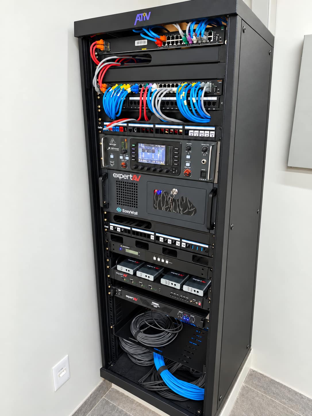 Rack audiovisual montado, com equipamentos e cabeamento identificados